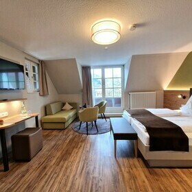 Zimmereinrichtung mit Doppelbett, TV und Sitzecke im G�stezimmer des Gasthaus goldener Engel